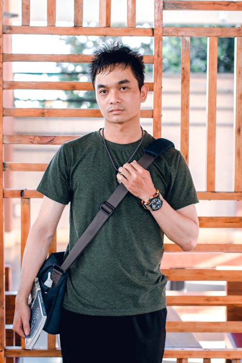 Man Holding Crossbody Bag Standing on Outdoors