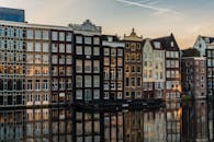日落时分，阿姆斯特丹标志性的运河房屋倒映在水中