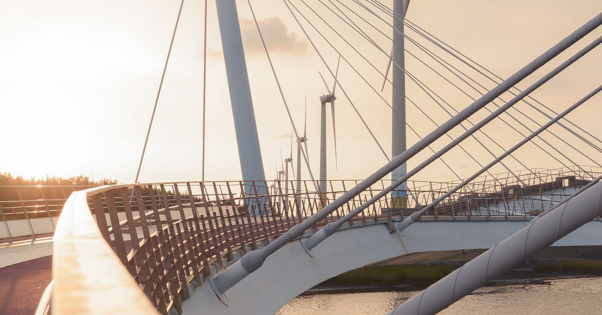 Windmaker Bridge Suspension Bridge over River and Wind Turbines in Morning Light · Free ...