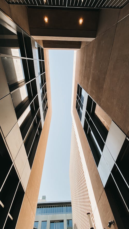 Foto d'estoc gratuïta de cel blau, edifici marró, exterior d'un edifici