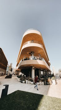 Stylish modern architecture featuring circular balconies and terraces, captured in a warm daylight setting.