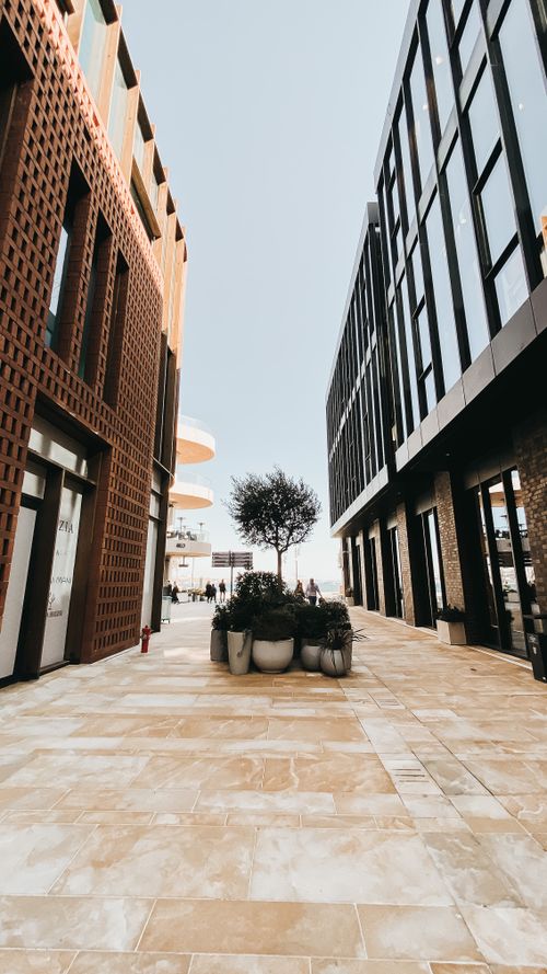 Free A vibrant urban alleyway showcasing modern building architecture in contrasting styles. Stock Photo