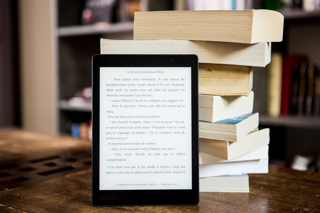 Free Black Tablet Computer Behind Books Stock Photo