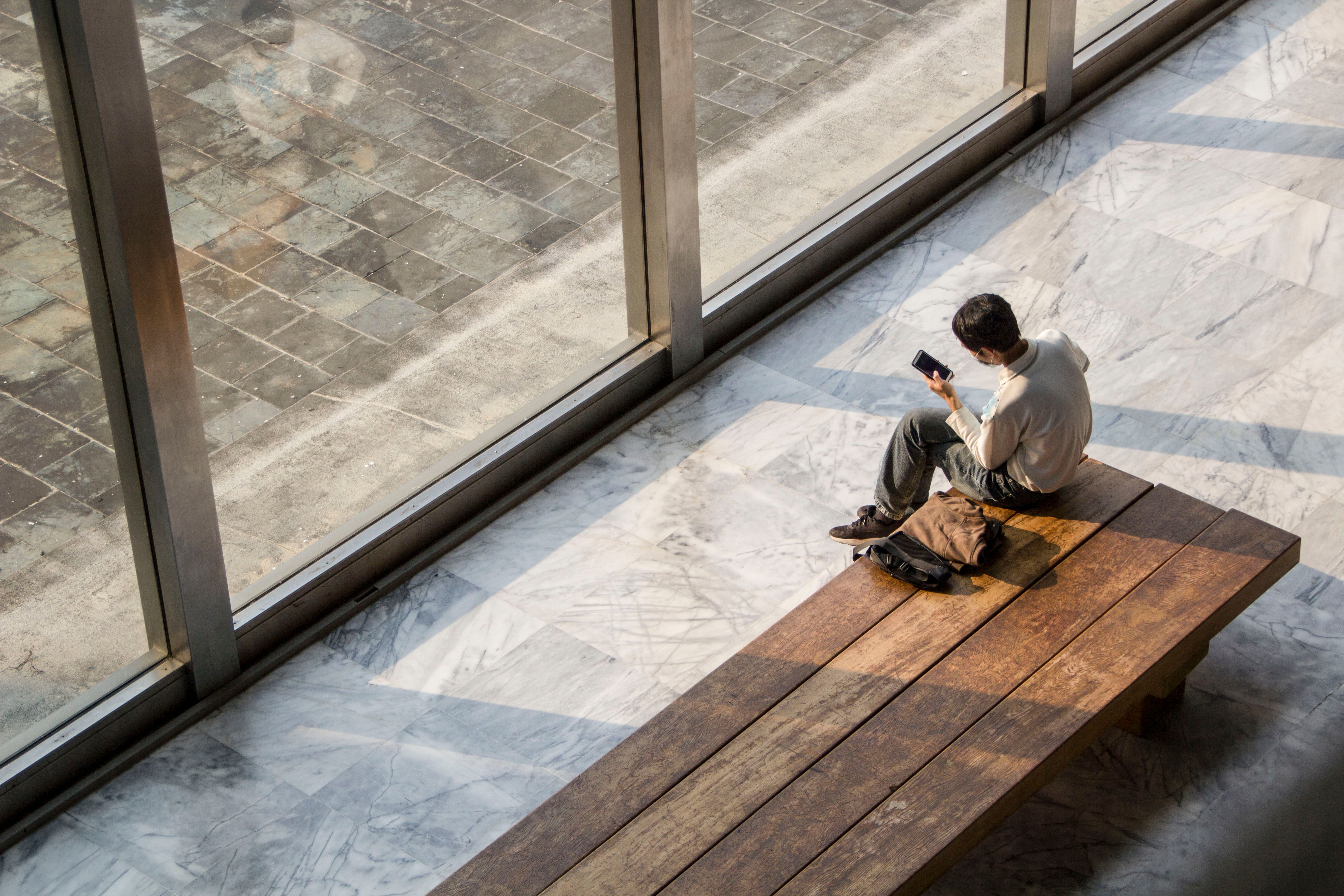 A person sitting alone in a quiet, empty stone chapel with sunlight streaming through a window