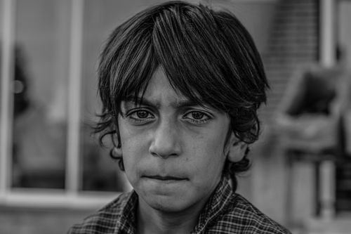 Free Monochrome close-up portrait of a thoughtful young boy outdoors in Jiroft, Iran. Stock Photo