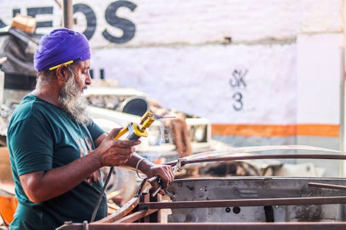 A Man Using Yellow Welding Machine