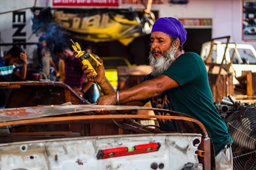 A Man Using Yellow Welding Machine