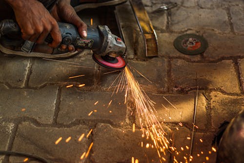 Free Person Using an Angle Grinder with Sparks Stock Photo