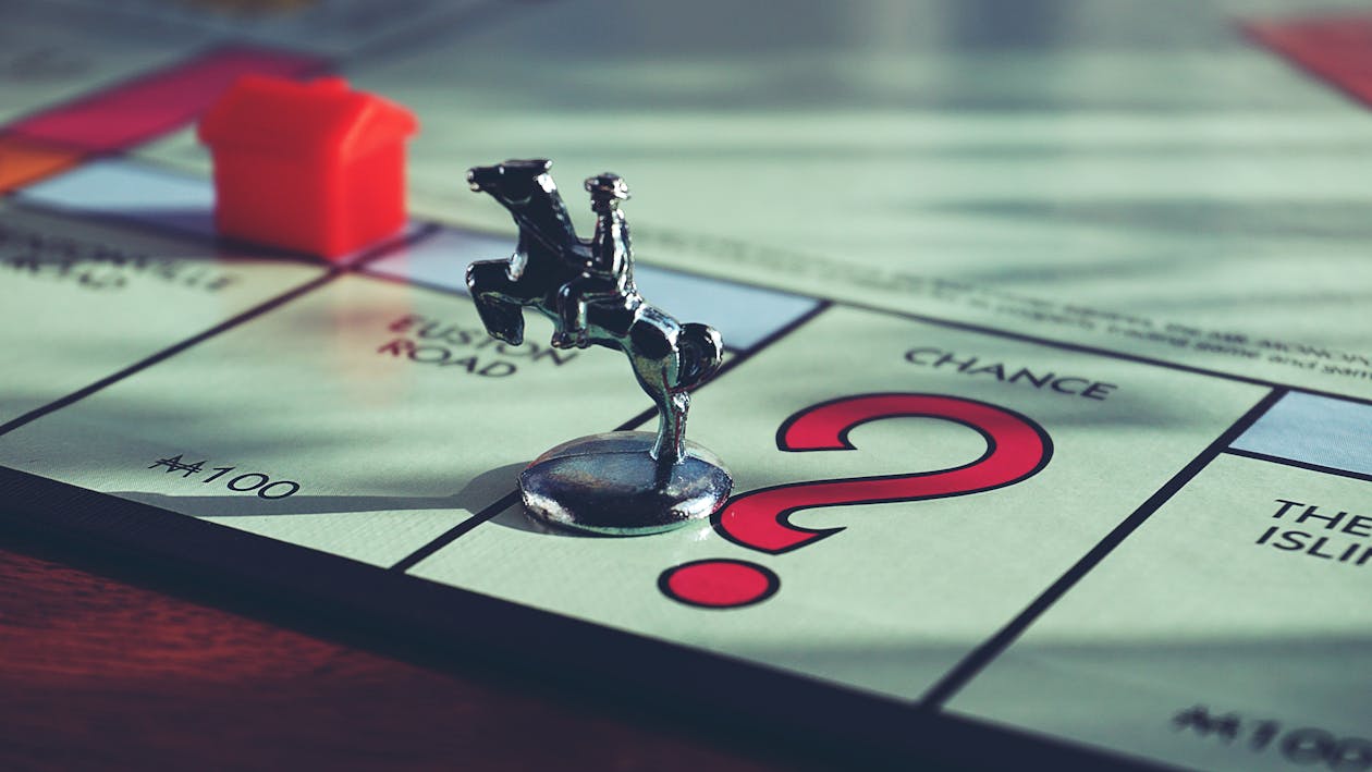 Free Horse Miniature Toy on Top of Monopoly Board Game  Stock Photo