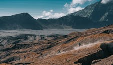 徒步旅行者欣赏着令人惊叹的山景，在崎岖的火山地形上徒步