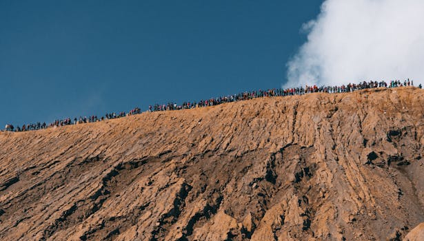 湛蓝的天空下，一大群人正沿着崎岖的山脊徒步旅行