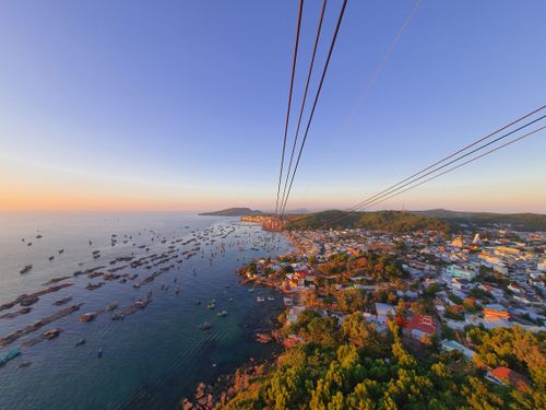Free A breathtaking aerial view of Phú Quốc's coastline at sunrise, showcasing the sea and vibrant town. Stock Photo