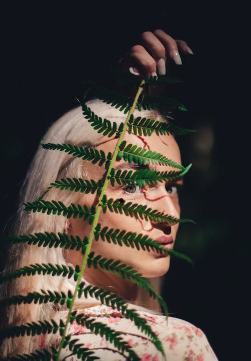 A Woman Holding Green Fern Leaves