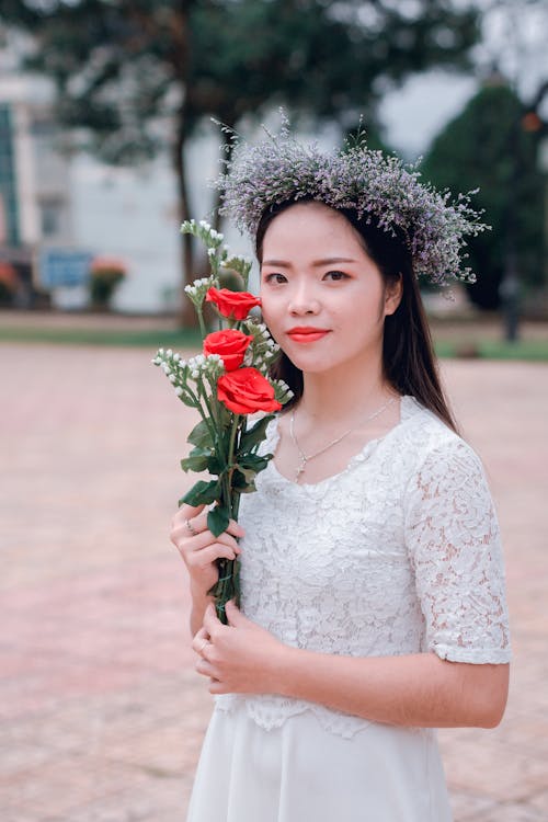 Selective Focus Photography of Woman Holding Three Red Rose Flowers