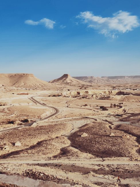 Explore the expansive arid landscape of Douiret, Tataouine, Tunisia with clear blue skies.