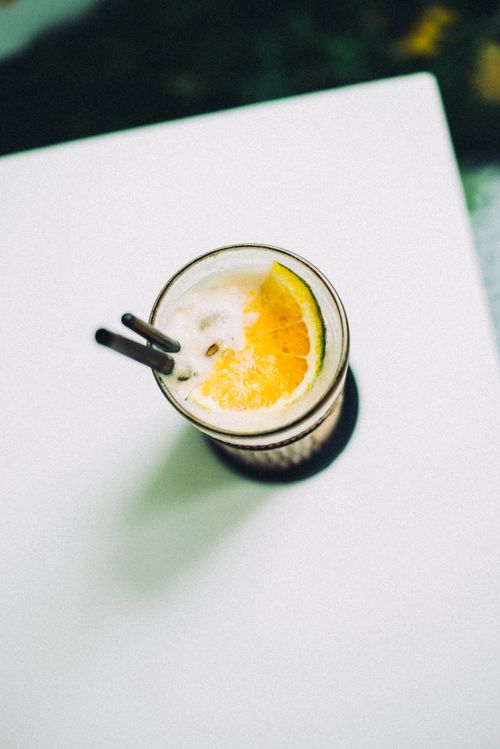 Free Aerial view of a lemon drink with straw on a white table, perfect for refreshing moments. Stock Photo