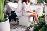 年轻夫妇在现代花园里，身着时尚服装与植物合影