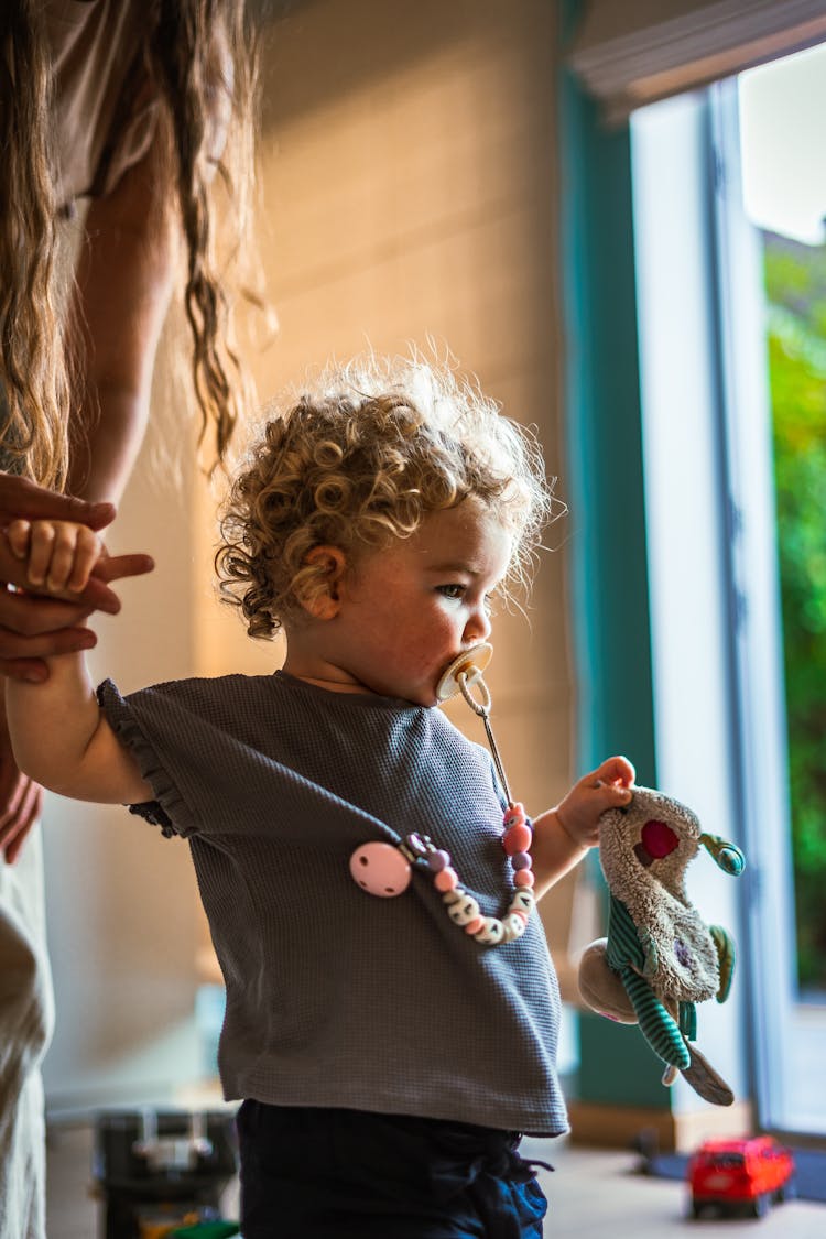 Woman Holding Baby Girl With Pacifier 