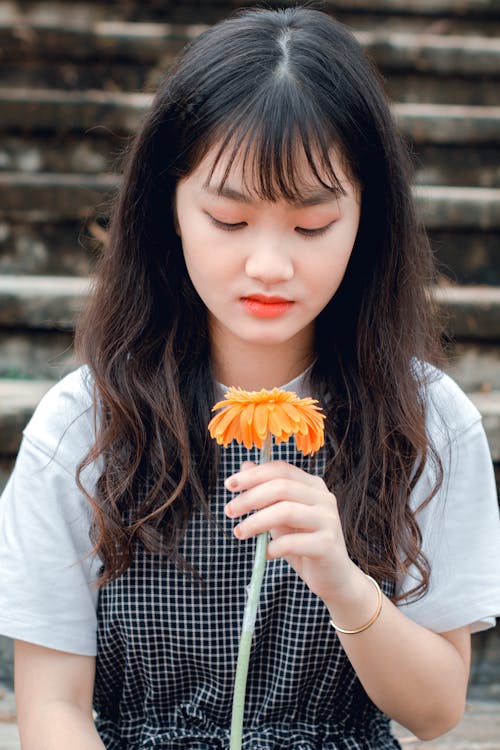 Girl Holding Orange Gerbera Daisy