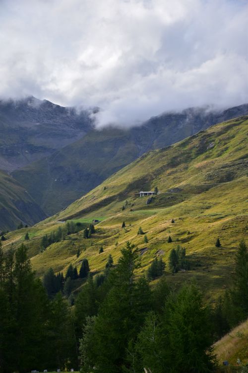 Free A scenic view of a green mountain valley shrouded in clouds, perfect for serene landscape photography. Stock Photo