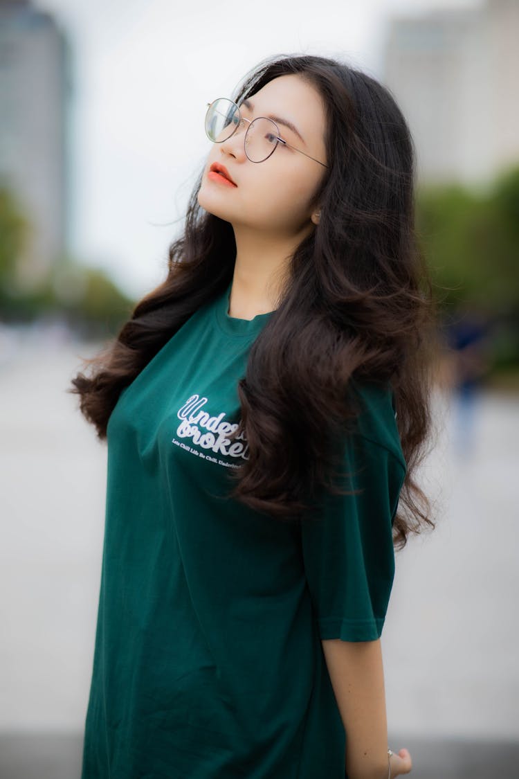 Woman In Green Oversized Shirt Wearing Eyeglasses While Posing At The Camera