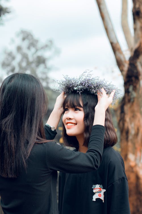 Free Woman Putting Crown to Another Woman Stock Photo