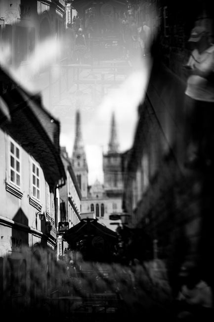 Artistic multiple exposure of a historic street with cathedral spires creating a moody atmosphere.