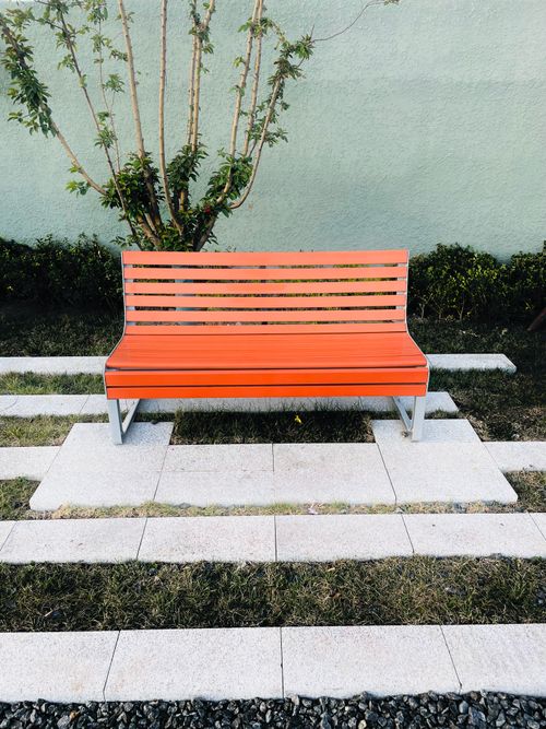 Free An orange bench set in a peaceful garden setting in Tianjin, China. Stock Photo