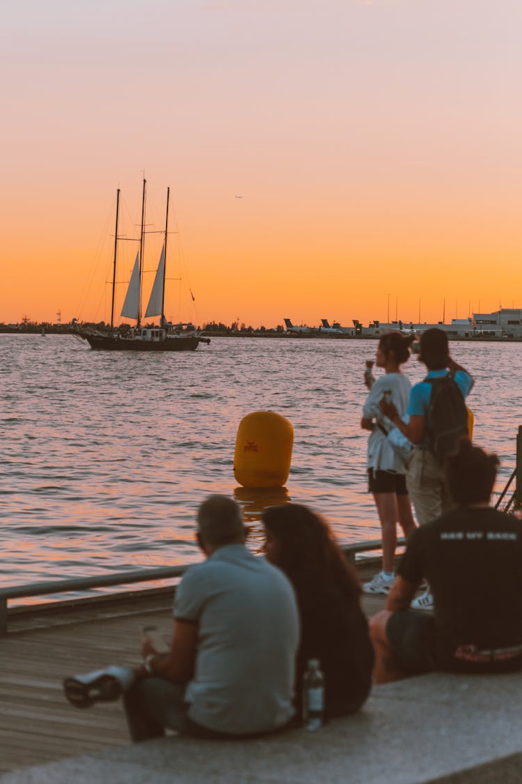 People Watching The Sunset On A Seashore 