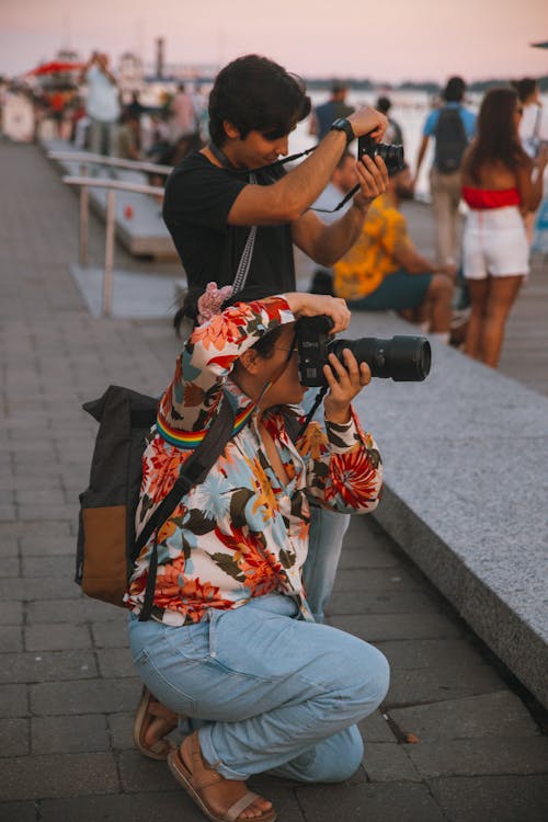 Man and Woman Holding DSLR Cameras