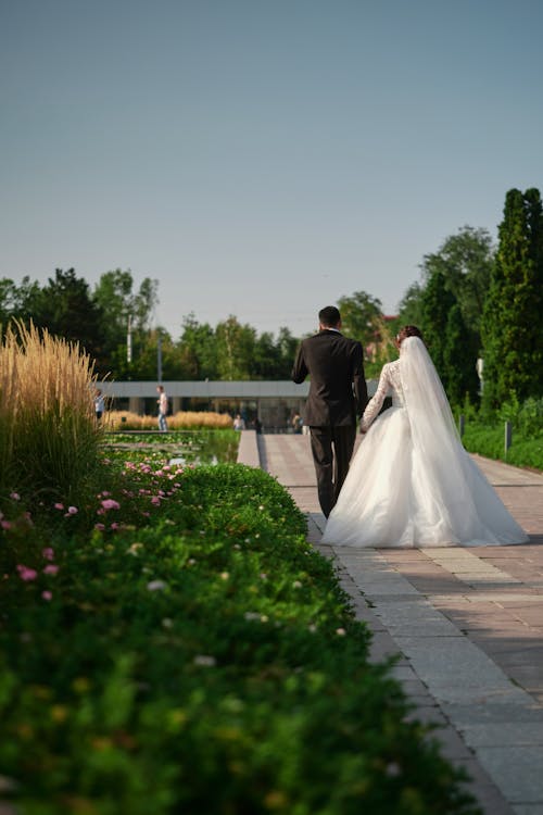 Bride and Groom Walking on Pathway