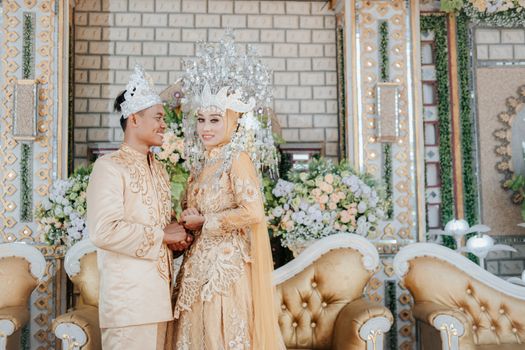 Stunning couple in traditional attire celebrating their marriage indoors. - Fotografer Sidoarjo
