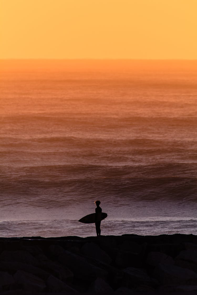 Silhouette Of Surfer At Sunrise