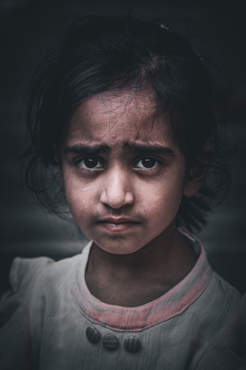 Free Close-up portrait of a pensive young girl with expressive eyes and a neutral background. Stock Photo