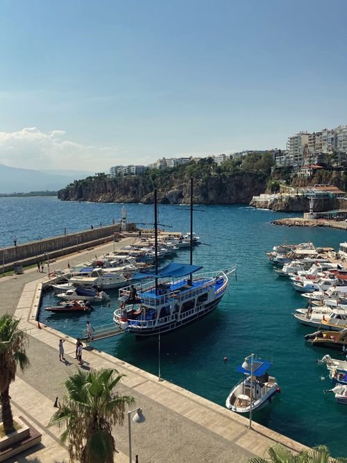 Free Vibrant harbor with boats docked in a Mediterranean cityscape, blue sky and coastline. Stock Photo