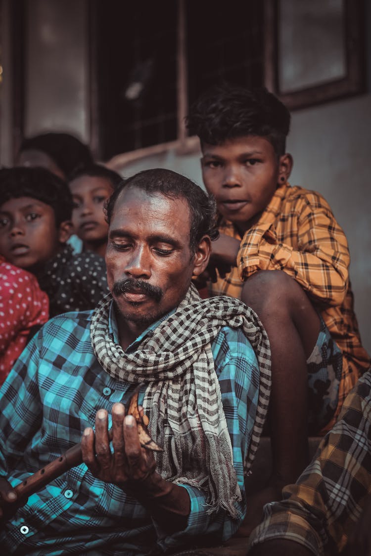 Family Wearing Patterned Shirts, And Father Holding A Flute