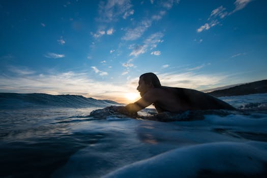 A man preparing to surf at sunset along the scenic Argentine coastline with waves crashing.