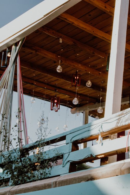 Free Charming outdoor patio featuring hanging lights and a wooden roof, creating a cozy ambiance. Stock Photo