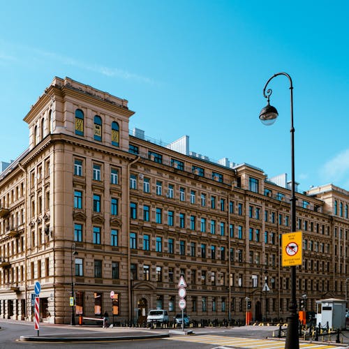 City Street with a Townhouse Corner and Lamppost against Blue Sky