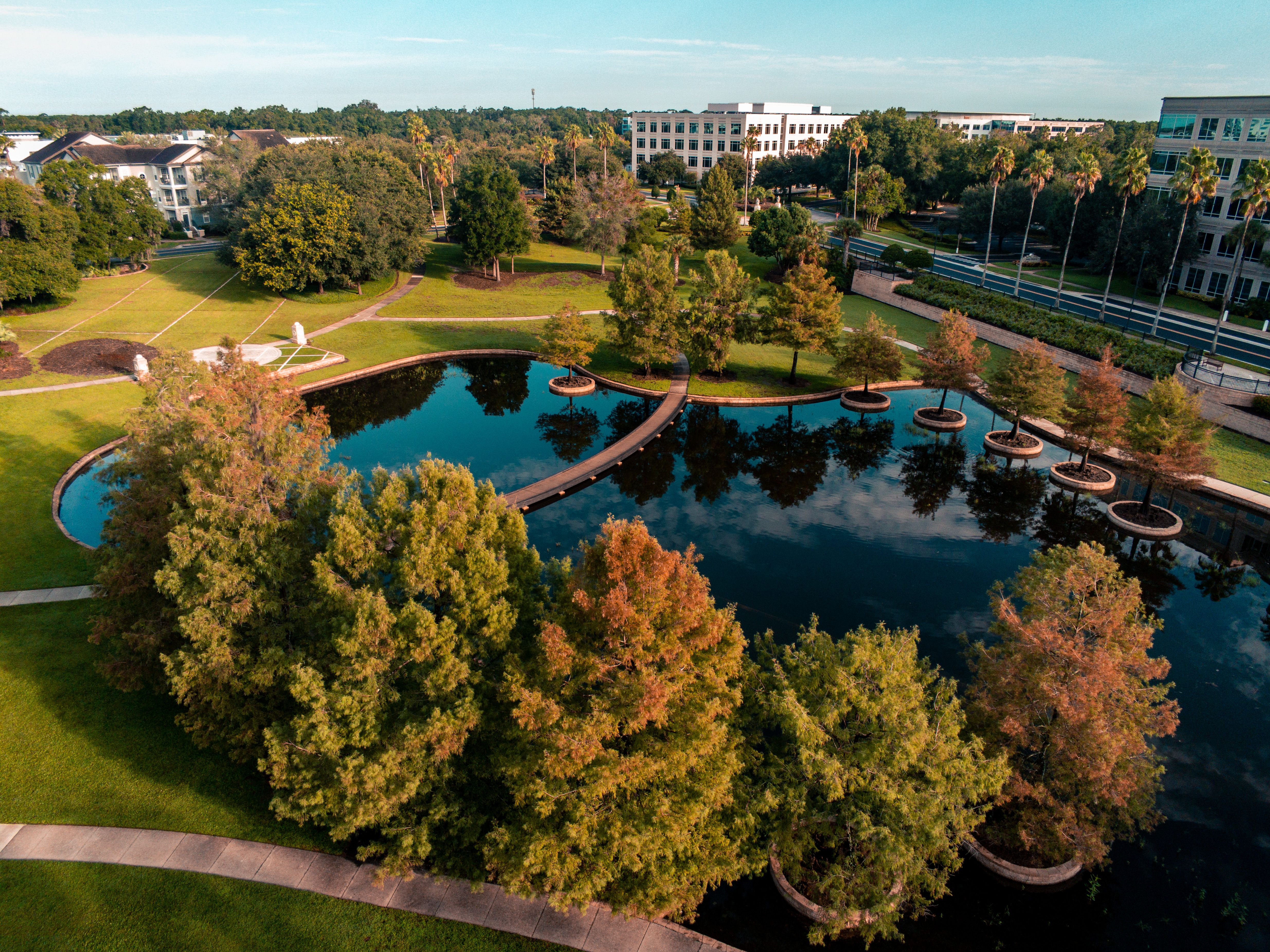 Breathtaking Take a Thrilling 85 Miles Private Helicopter Tour to Space Coast Review 2026 - Beautiful aerial view of a park with a pond in Lake Mary, Florida, showcasing autumn foliage.