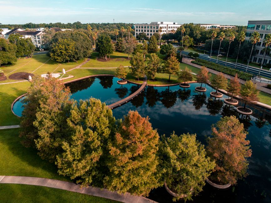 Breathtaking Take a Thrilling 85 Miles Private Helicopter Tour to Space Coast Review 2026 - Beautiful aerial view of a park with a pond in Lake Mary, Florida, showcasing autumn foliage.