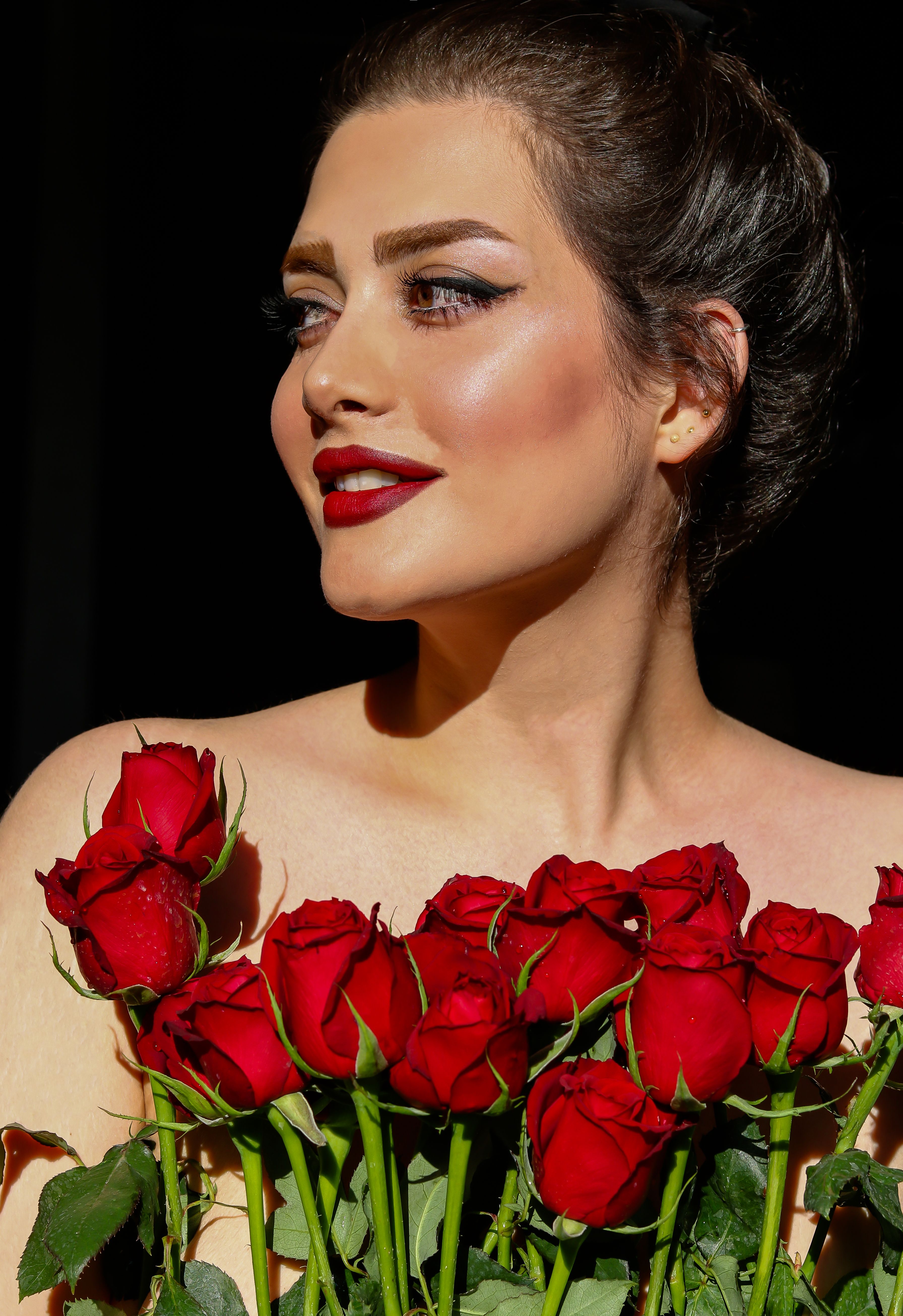 Close-Up Shot of a Woman Holding Red Roses · Free Stock Photo