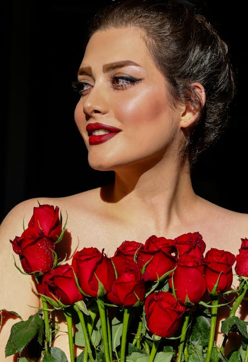 Close-Up Shot of a Woman Holding Red Roses