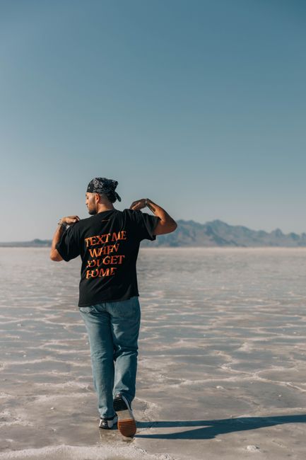 Back view of a young man walking on salt flats wearing a graphic tee. Back view of a young man walking on salt flats wearing a graphic tee.