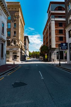 Wide urban street view with historic and modern buildings under a clear sky.
