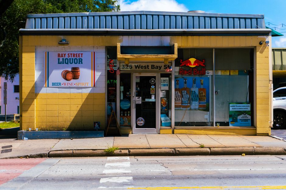 Bright exterior of Bay Street Liquor store with sidewalk view and vibrant signage. - Traditional Bajan Food Guide (Local Dishes)