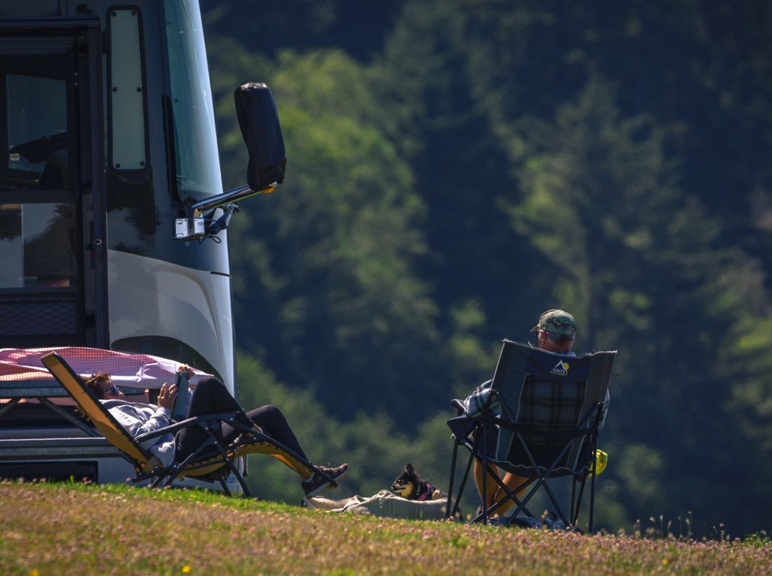 A couple relaxing by their RV at the campsite