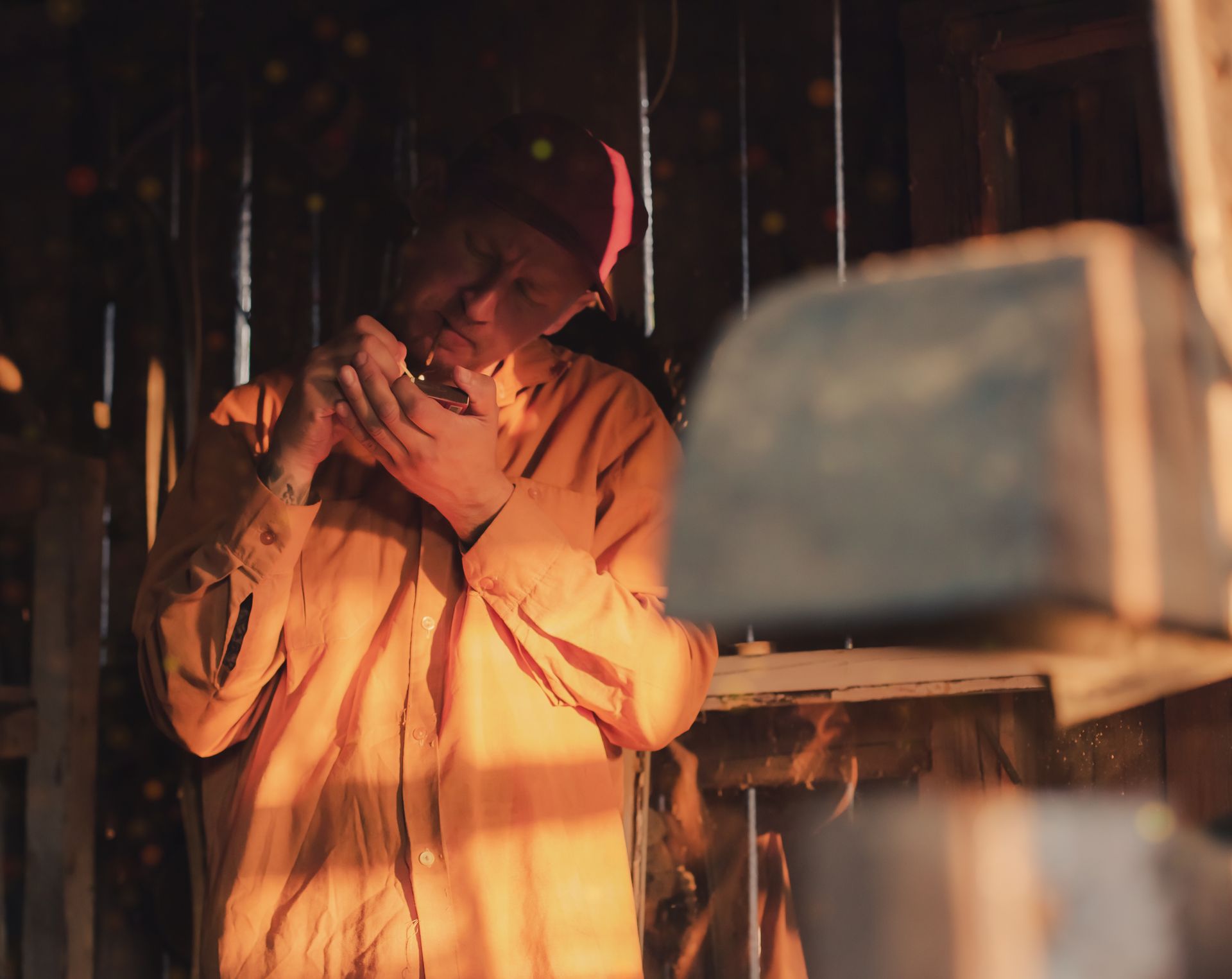 A mid-adult caucasian man skillfully repairs electrical equipment in a warmly lit workshop.