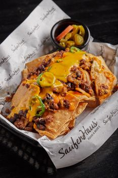 Close-up of tasty nachos topped with cheese, beef, and jalapenos, served in Monterrey, Mexico.