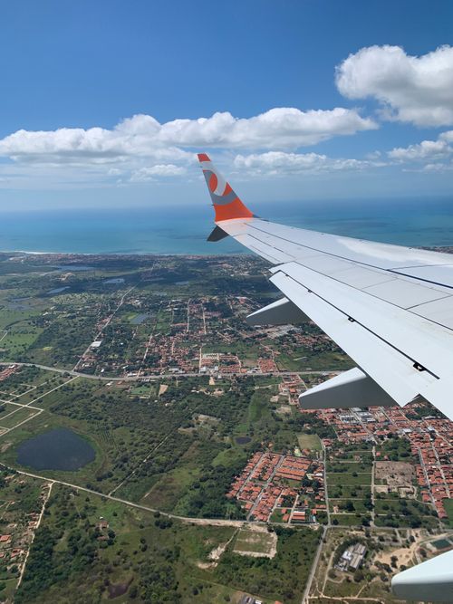 Free Aerial view from airplane window showcasing scenic city landscape and coastline. Stock Photo